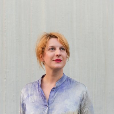 Portrait von Sabine-Lydia Schmidt vor einem weißen Hintergrund